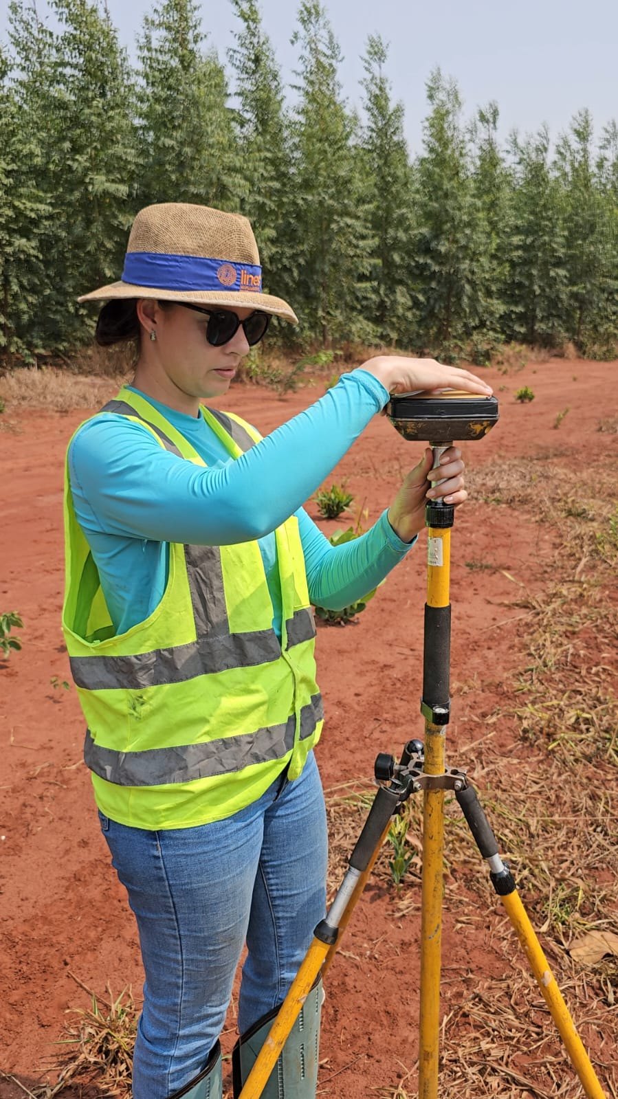 Piloto em campo operando equipamento topográfico